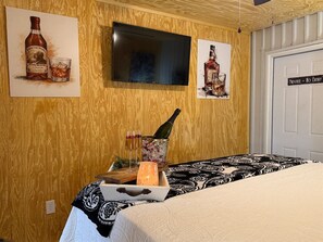 A bedroom with a bed, a television, a wooden wall, and a door labeled 'PRIVATE - NO ENTRY'.