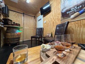A bar area with a wooden interior, a television mounted on the wall, and a wooden barrel.