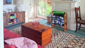 Una sala de estar con chimenea, un televisor montado encima y una estantería, con puerta a un balcón.