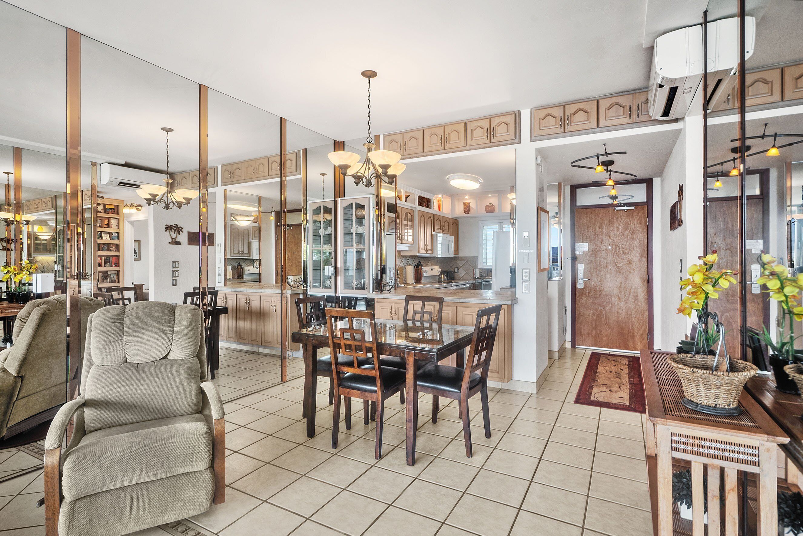 A spacious living area with a dining table, comfortable seating, and a kitchen in the background.