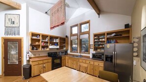 Cocina compacta con armarios de madera, una isla central y un refrigerador integrado.