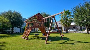 Ein Spielplatz mit Schaukeln und Klettergerüsten.
