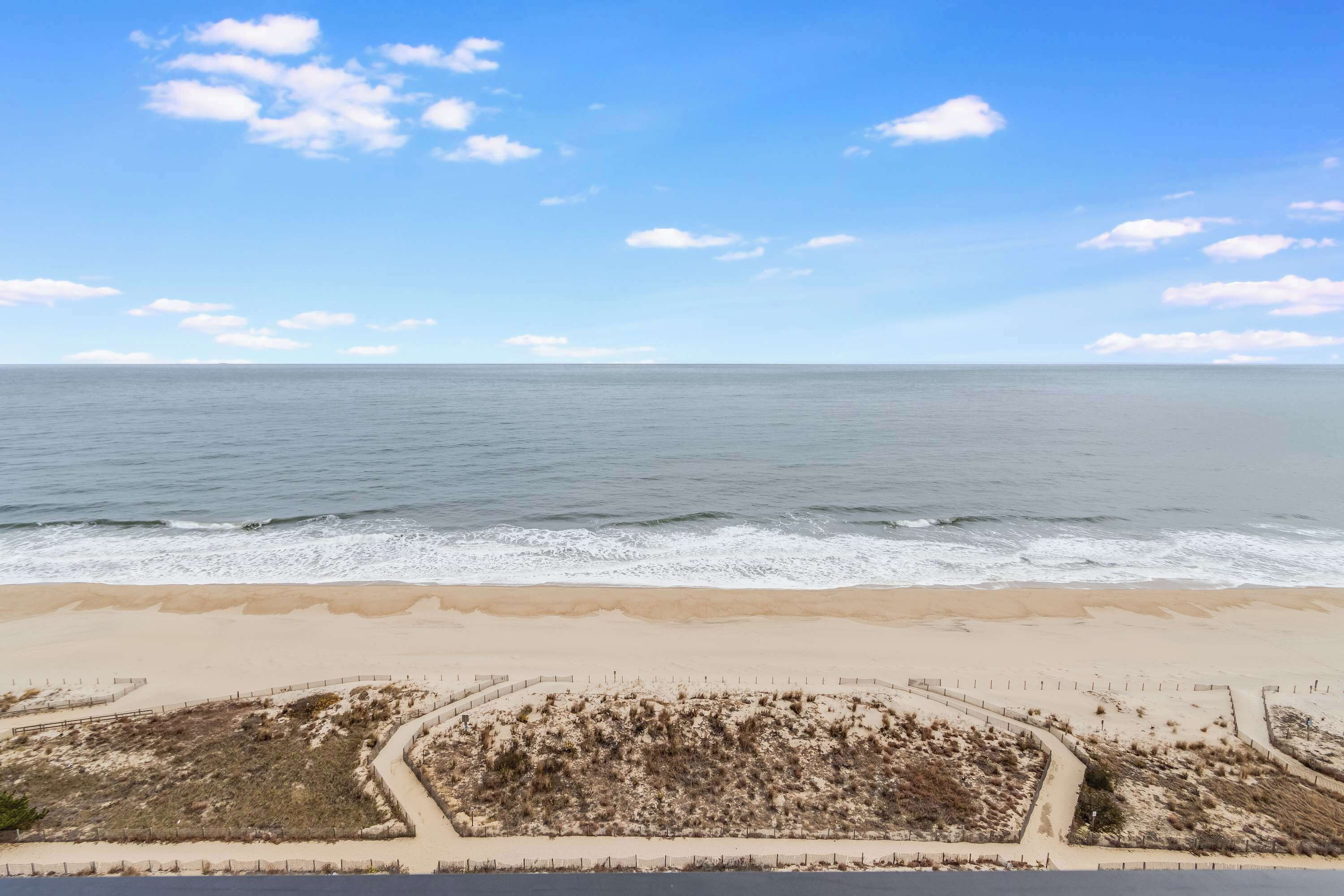 Una playa con un área cercada y vista al océano.