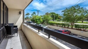 Un balcone con vista sulla strada, una sedia e una ringhiera.