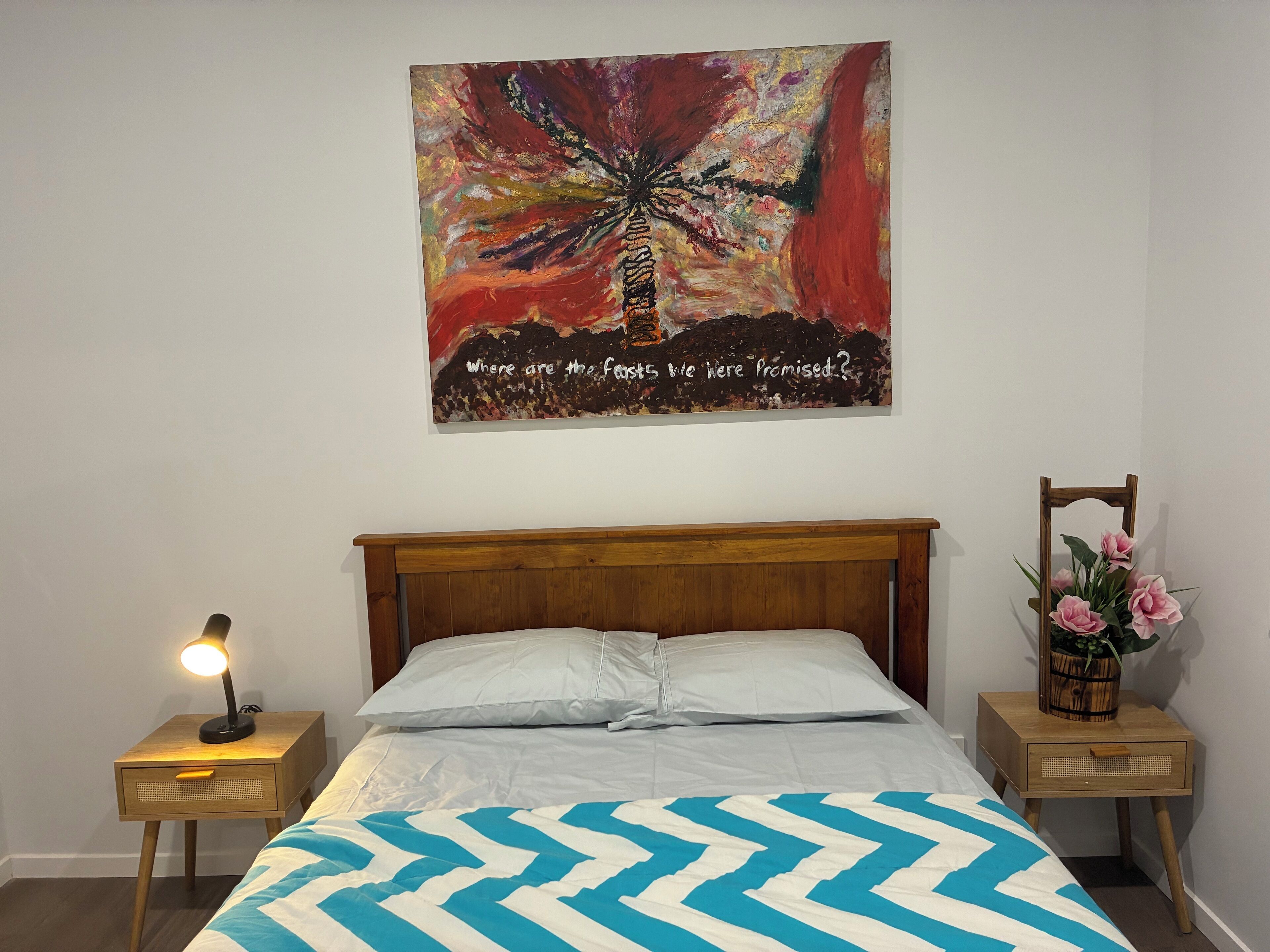 Double bed with side table table lamps and linen