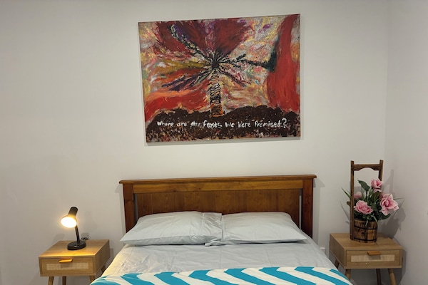 Double bed with side table table lamps and linen