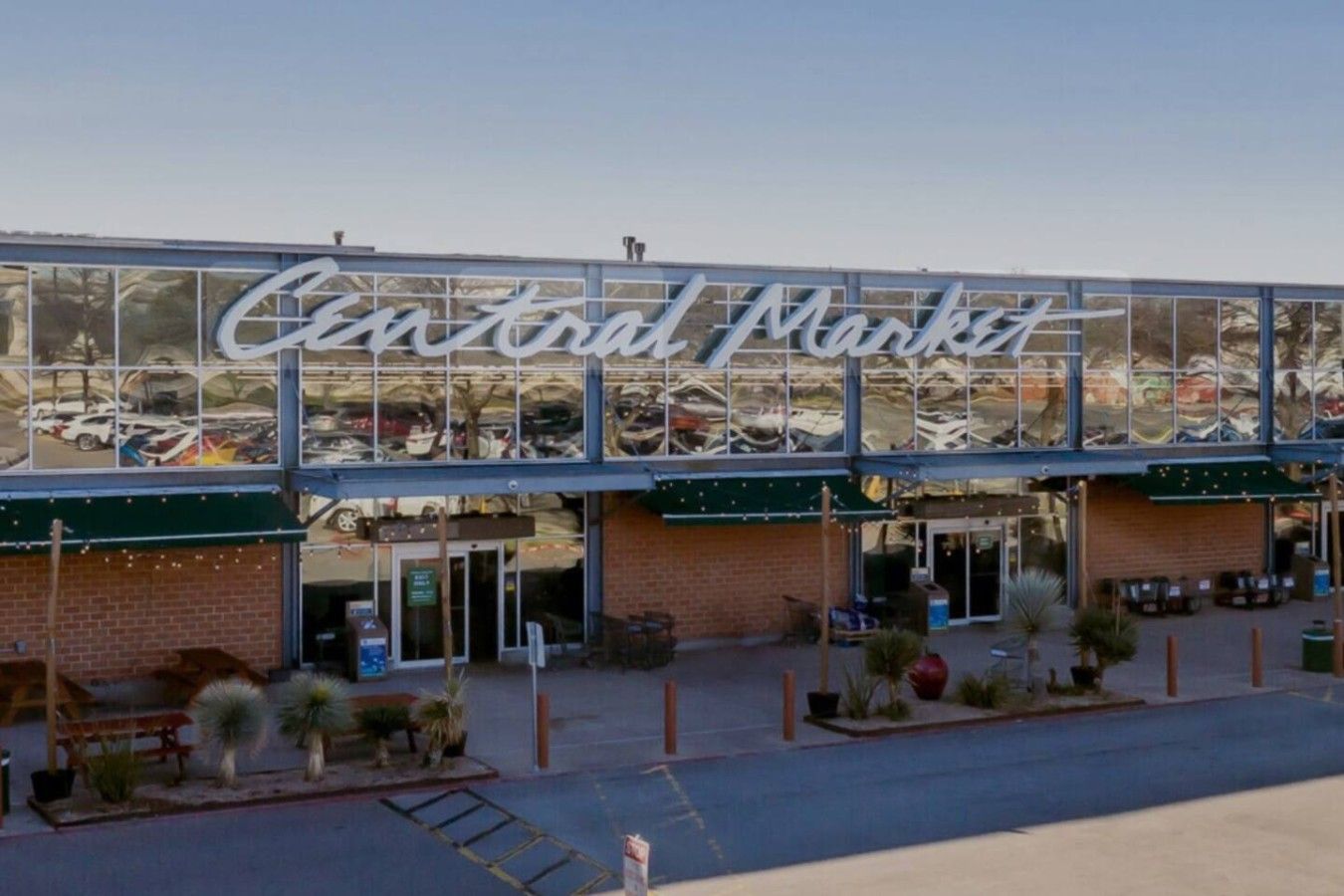 Un edificio con un letrero grande que dice 'Central Market' y un estacionamiento al frente.
