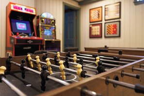 A foosball table in a room with arcade games and framed pictures on the wall. - Sleeps 18+| Hot Tub| Sauna | 7BR Mountain Retreat (Conway)