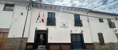 A building with a sign reading "PALACE DIAZ" and multiple flags.