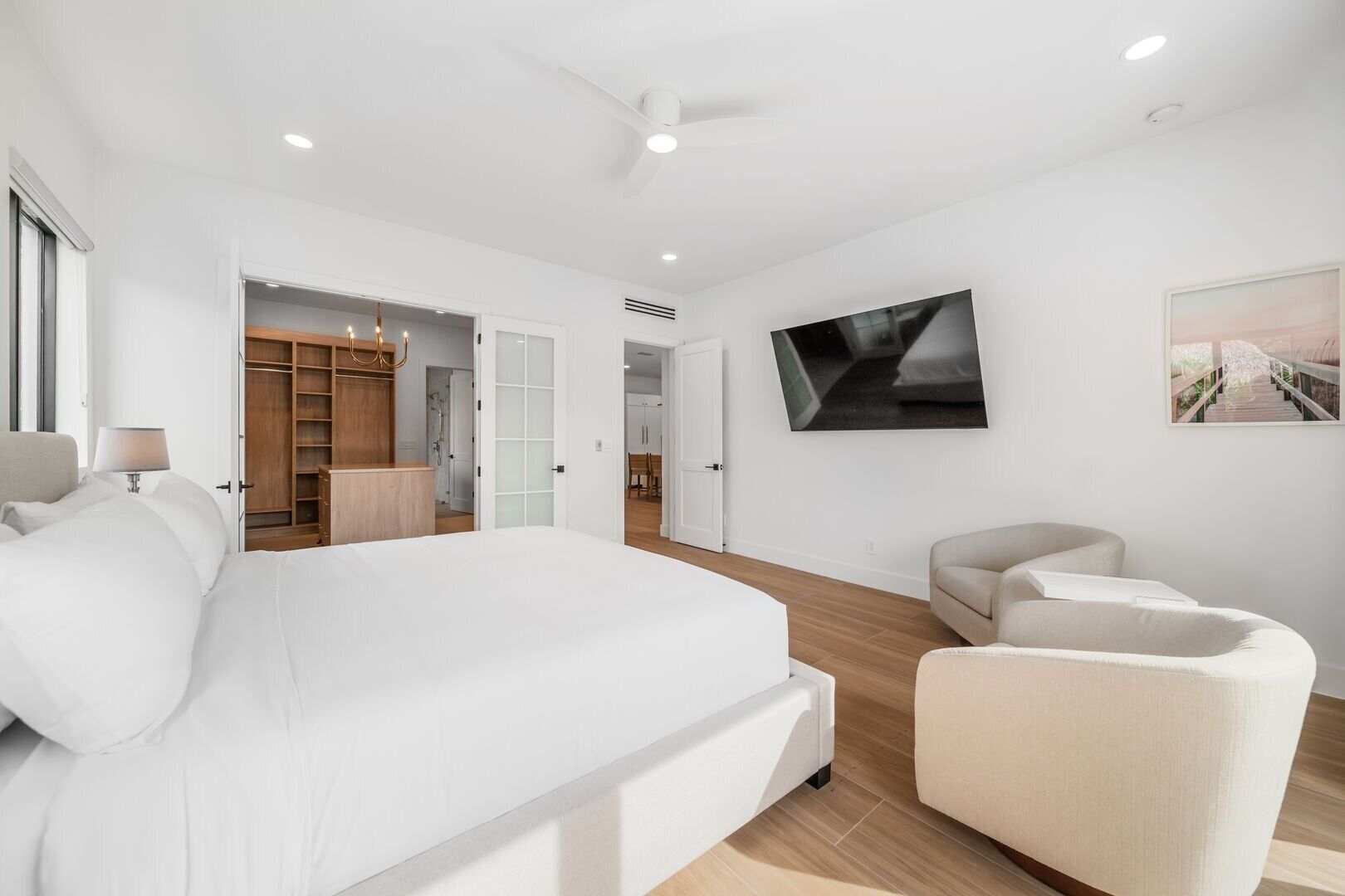 Een moderne hotelkamer met een groot bed, een zithoek en een televisie aan de muur.