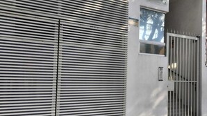 A closed metal shutter door with a security keypad and a metal gate. - CDMX Alamos : World Cup 2026 : 3 Rec 6p : Downtown, Roma, GNP Stadium (Ciudad de México)