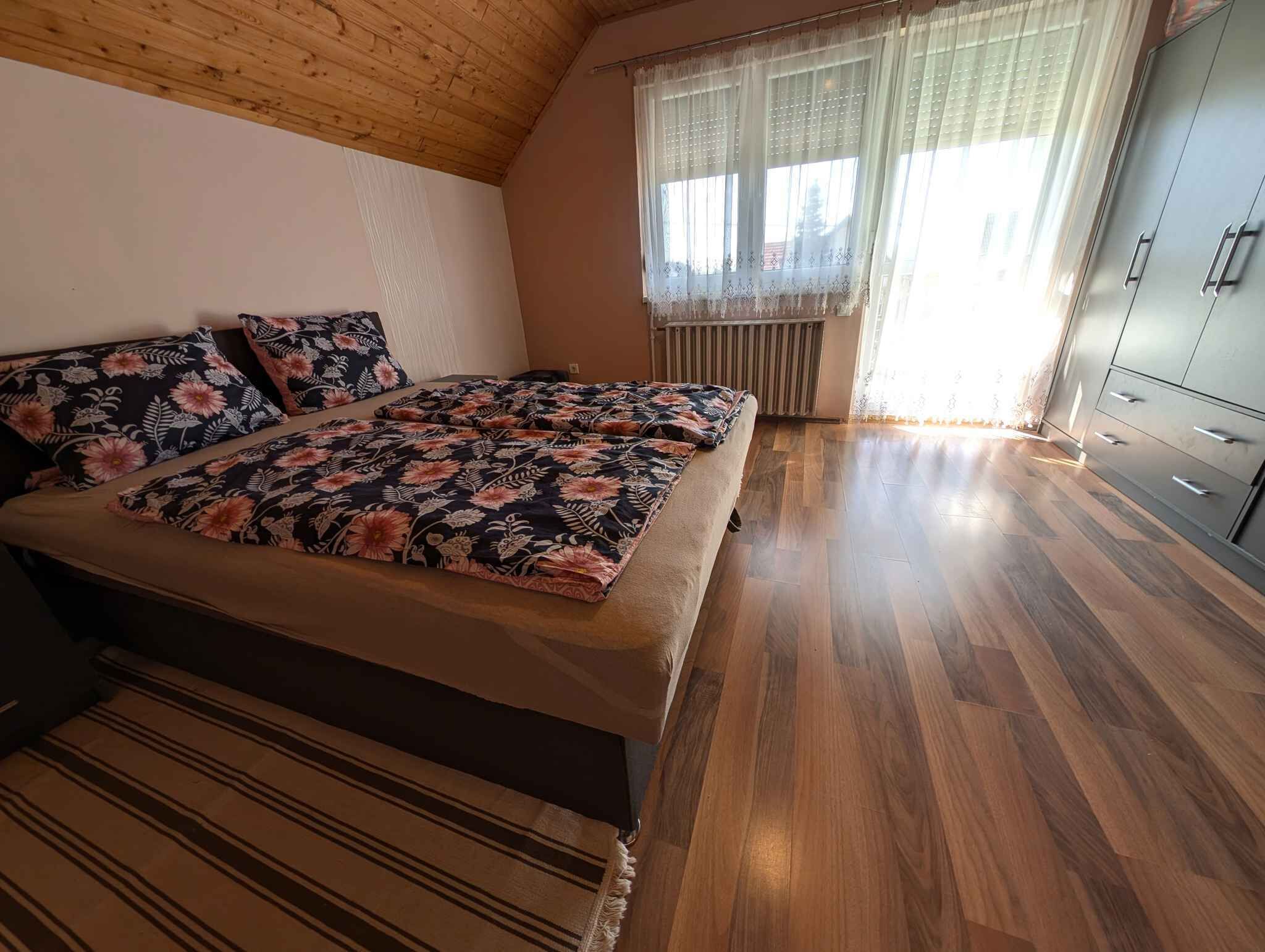 Ein Schlafzimmer mit Bett, Heizkörper und Kleiderschrank.