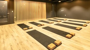 Een kamer met meerdere yogamatten en houten blokken, klaar voor een yogales.