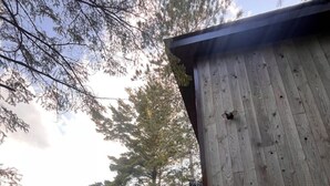 En træhytte med en terrasse og et skilt, der står "Moose".