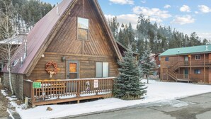 A wooden cabin with a triangular roof, a porch, and a wreath decoration. - New Listing! Ski In Ski Out! "HH Creeks Legacy" Updated Cabin-In Town-Close to Copper Chairlift (Red River)