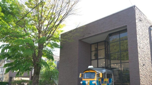 A tuk-tuk parked in front of a building with a brick facade and large windows. - HOTEL Reise Basis (Senboku)