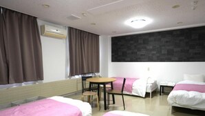 A hotel room with two beds, a small table, and chairs. There is a window with curtains, an air conditioning unit, and a wall-mounted light fixture. - HOTEL Reise Basis (Senboku)