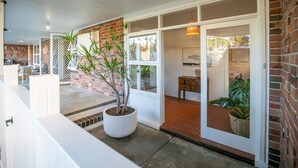 Un interior moderno con pared de ladrillo, puerta blanca y planta en maceta.