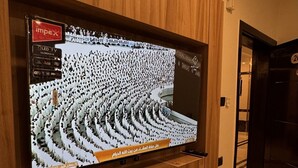 Un televisor montado en una pared de madera con un estante debajo.
