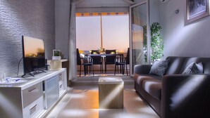 A modern living room with a flat-screen TV, a sofa, a coffee table, and a dining area with chairs and a table. - Wohnung in Žnjan by Interhome (Dragovode)
