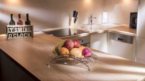 A modern kitchen with a wooden countertop, a fruit bowl, a wine rack, and a sink. - Wohnung in Žnjan by Interhome (Dragovode)