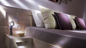 A modern bedroom with a bed, nightstand, and a decorative sculpture. - Wohnung in Žnjan by Interhome (Dragovode)