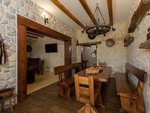 A rustic dining area with stone walls, wooden benches, and a chandelier. - Historische Steinvilla Heaven für 11 Personen by Interhome (Gornje Postinje)