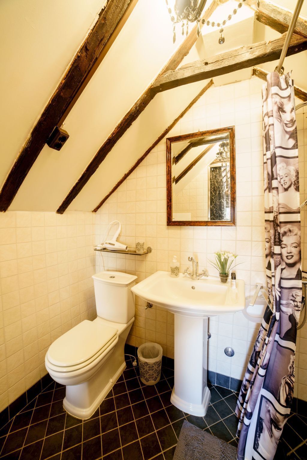 A bathroom with a toilet, sink, and mirror.