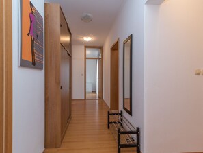 A hallway with wooden flooring, a bench, and a door leading to another room. - "Emelie" mit Blick auf das Wasser by Interhome (Trogir/Okrug Donji)