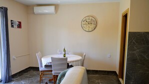 Un comedor con una mesa redonda, sillas y un reloj en la pared.