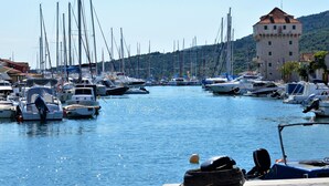 A marina with numerous boats docked, a prominent building with a tower, and a hilly landscape in the background. - Wohnung in Marina mit Parkplatz, schöne Aussicht by Interhome (Marina)