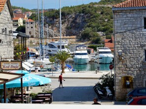 A marina with boats docked, a stone building, and a sign for 'Konoba - Pizzeria'. - Wohnung in Marina mit Parkplatz, schöne Aussicht by Interhome (Marina)