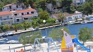 A playground with a slide and swings near a marina with boats. - Erdgeschosswohnung, erste Reihe vom Meer by Interhome (Marina)