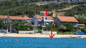 A coastal residential area with houses, a beach, and a clear view of the sea. - Erdgeschosswohnung, erste Reihe vom Meer by Interhome (Marina)