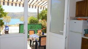 Una cocina con vistas a un lago, una mesa con sillas y una motocicleta estacionada afuera.