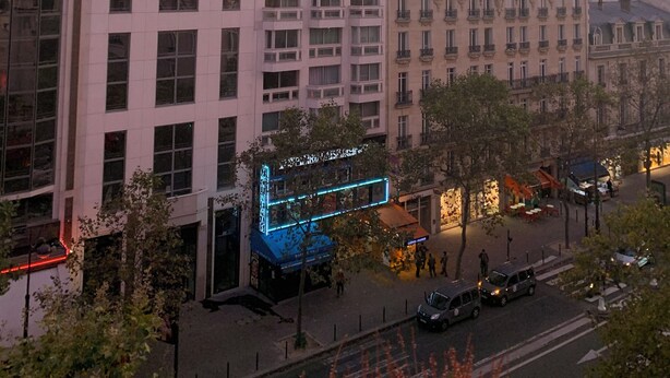 A cityscape with modern and historic buildings, a river, and a blue-lit building in the foreground. - Cosy bed Montparnasse (Paris)