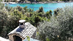 Ein Küstdorf mit Steinhäusern, blauem Meer und üppiger Vegetation.