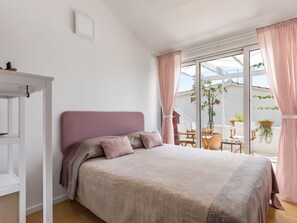 A bedroom with a bed, a wardrobe, and a balcony with plants. - mit Blick auf das Wasser by Interhome (Podorljak)