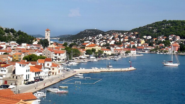 A coastal town with a prominent tower, marina, and densely packed buildings with red-tiled roofs. - in Tisno mit Terrasse und Grill by Interhome (Tisno)