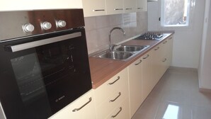 Een keuken met een Bosch oven, een spoelbak en een raam.