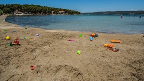 A sandy beach with scattered toys and a clear blue sky. - Wohnung "Mama Roza" mit Blick auf das Wasser by Interhome (Pašman/Pašman)