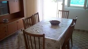 Un comedor con una mesa cubierta por un mantel floral, rodeado de sillas de madera.