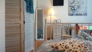 A bedroom with a bed, a TV, a painting, and a wardrobe. - Studio-Apartment mit Balkon und Meerblick by Interhome (Debeljak)