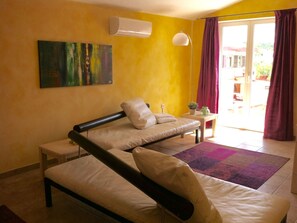A room with a bed, a sofa, a small table, a lamp, and a painting on the wall. - Gemütliche Ferienwohnung nahe Zadar by Interhome (Novigrad (Zadar))
