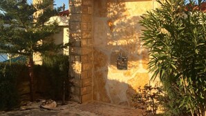 Ein Poolbereich mit einer Steinmauer, einem gefliesten Pool und einer Pergola mit Solarzellen.