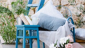 A blue metal chair with cushions, a metal bucket, and a small potted plant. - Mediterranes Haus mit privatem Garten und Pool by Interhome (Drivenik)
