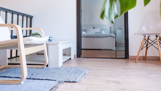 A modern bedroom with a wooden bed, a small bedside table, and a chair. There is a large window with a view of the outside. - Mediterranes Haus mit privatem Garten und Pool by Interhome (Drivenik)