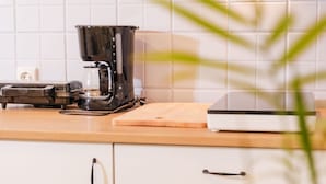 A kitchen with a coffee maker, a cutting board, and a digital clock displaying 18:59. - Mediterranes Haus mit privatem Garten und Pool by Interhome (Drivenik)