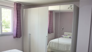 A bedroom with a bed, a wardrobe, and a mirror. - Gemütliche Wohnung Andrea in Opatija by Interhome (Opatija/Pobri)