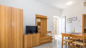 Una cocina moderna con armarios de madera, un televisor integrado y un comedor con mesa y sillas.